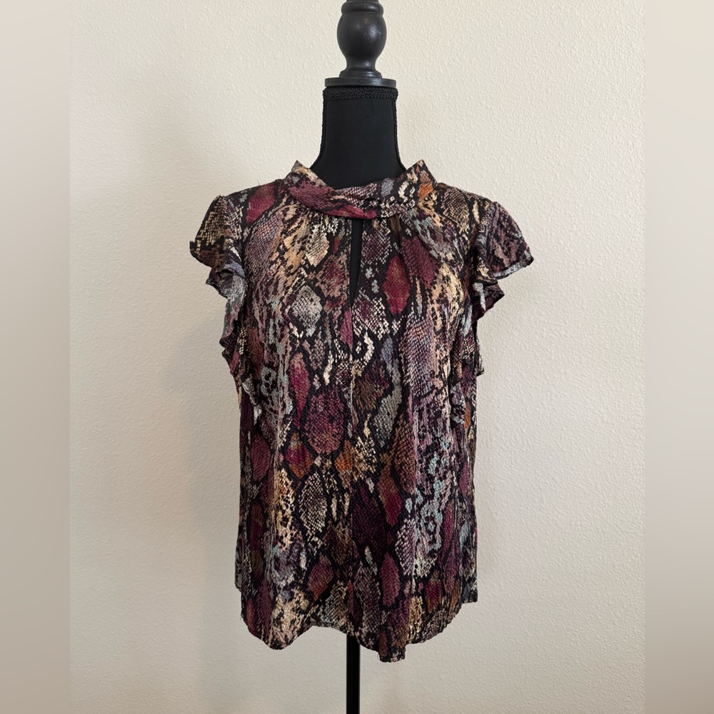 Silk top with keyhole neckline and ruffle sleeves.